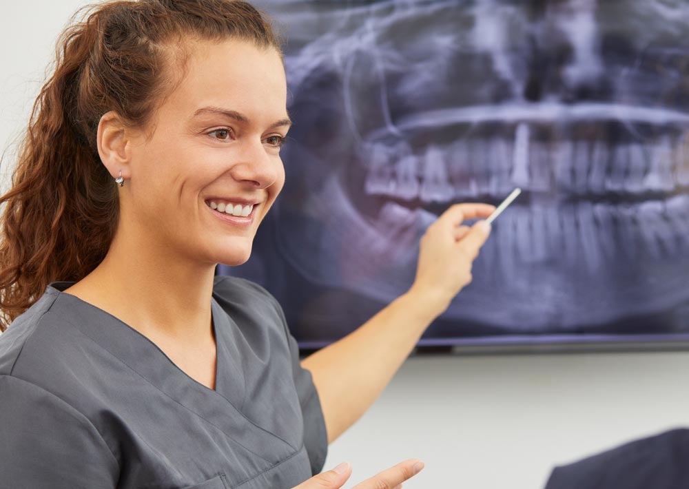 Foto einer Zahnärztin vor einem Röntgenbild