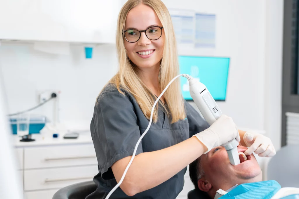 Zahnärztin nutzt Intraoralscanner um einen "Abdruck" des Gebisses vom Patienten zu bekommen